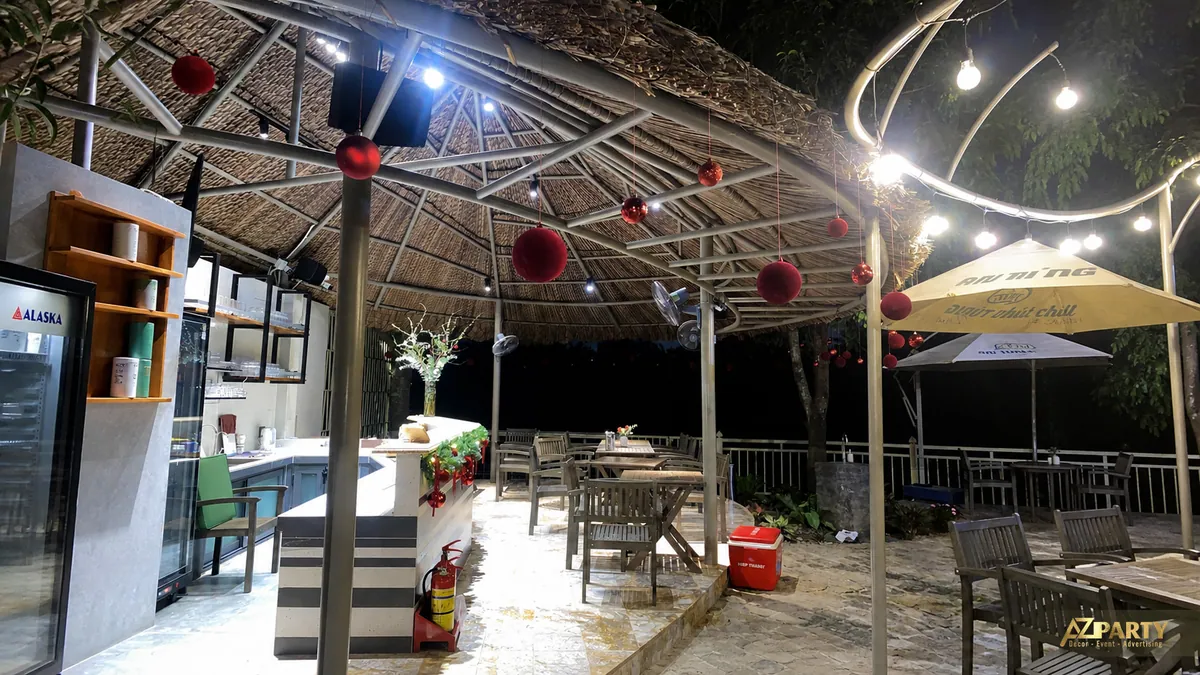 Không gian sân ngoài trời dưới mái che với đèn vàng và đồ trang trí Noel đỏ