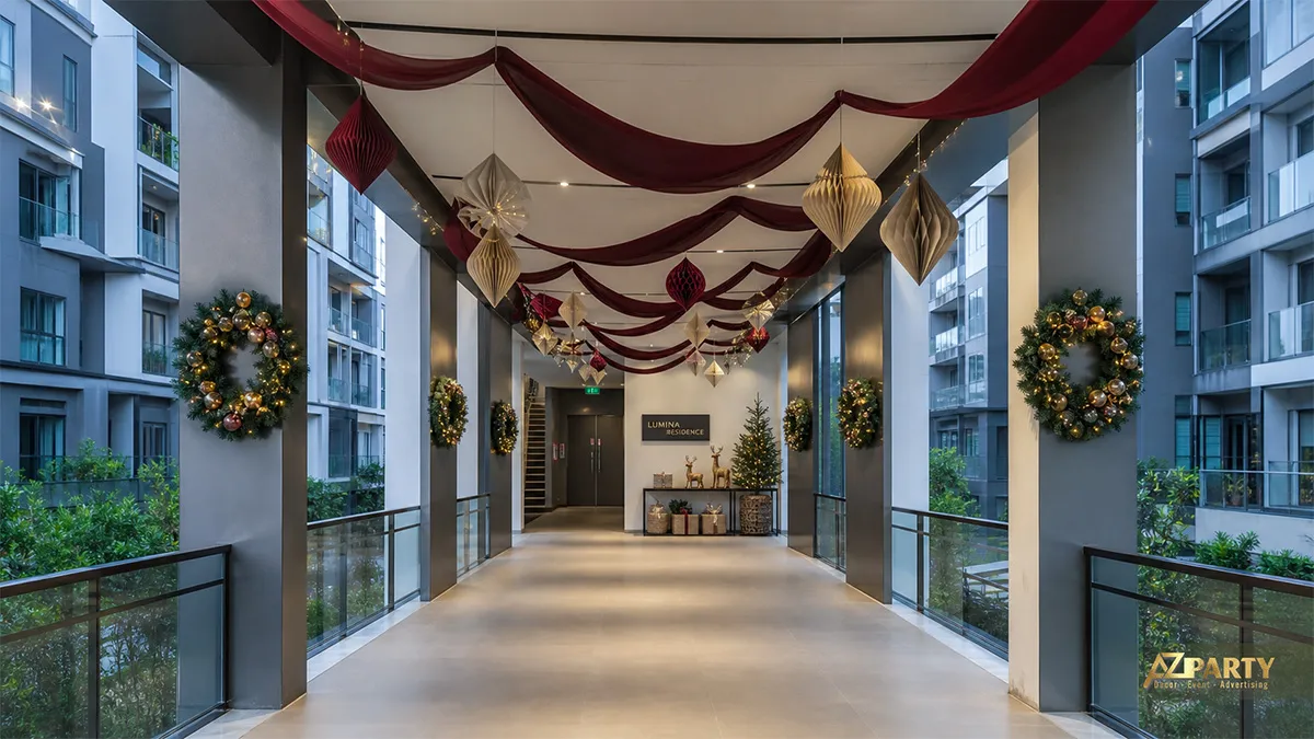 Hành lang Lumina Residence với rèm burgundy, đèn lồng giấy, vòng lá và cây thông nhỏ