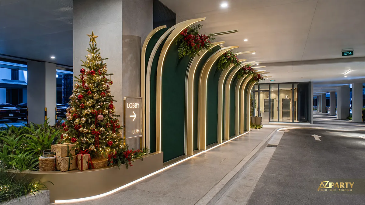Hành lang xe với các vòm xanh gắn đèn, cây thông đỏ vàng và bảng LOBBY