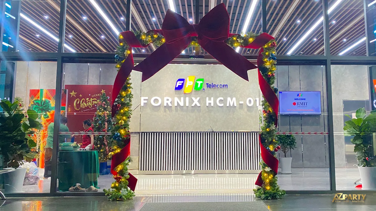 Lối vào sảnh được trang trí bằng nơ đỏ lớn và cụm thông Noel