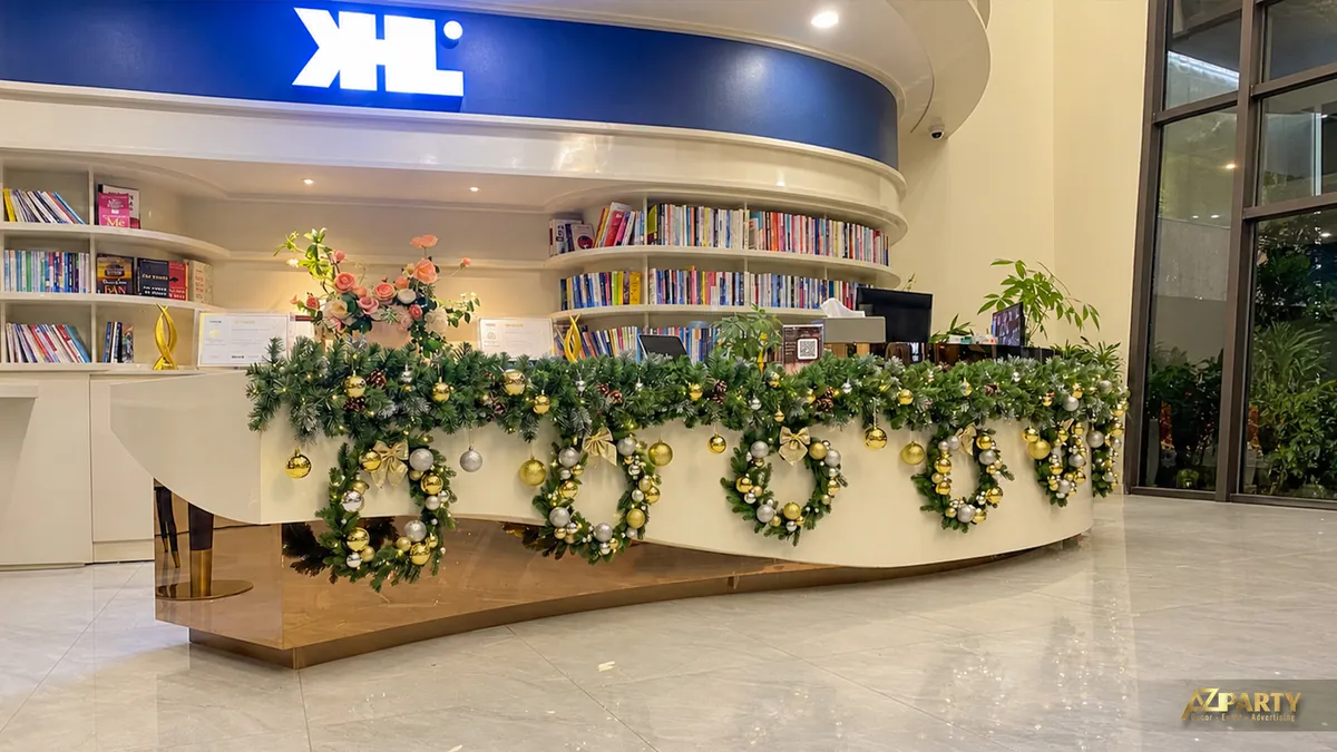 Quầy lễ tân có bảng hiệu XL và dây thông Noel màu xanh vàng