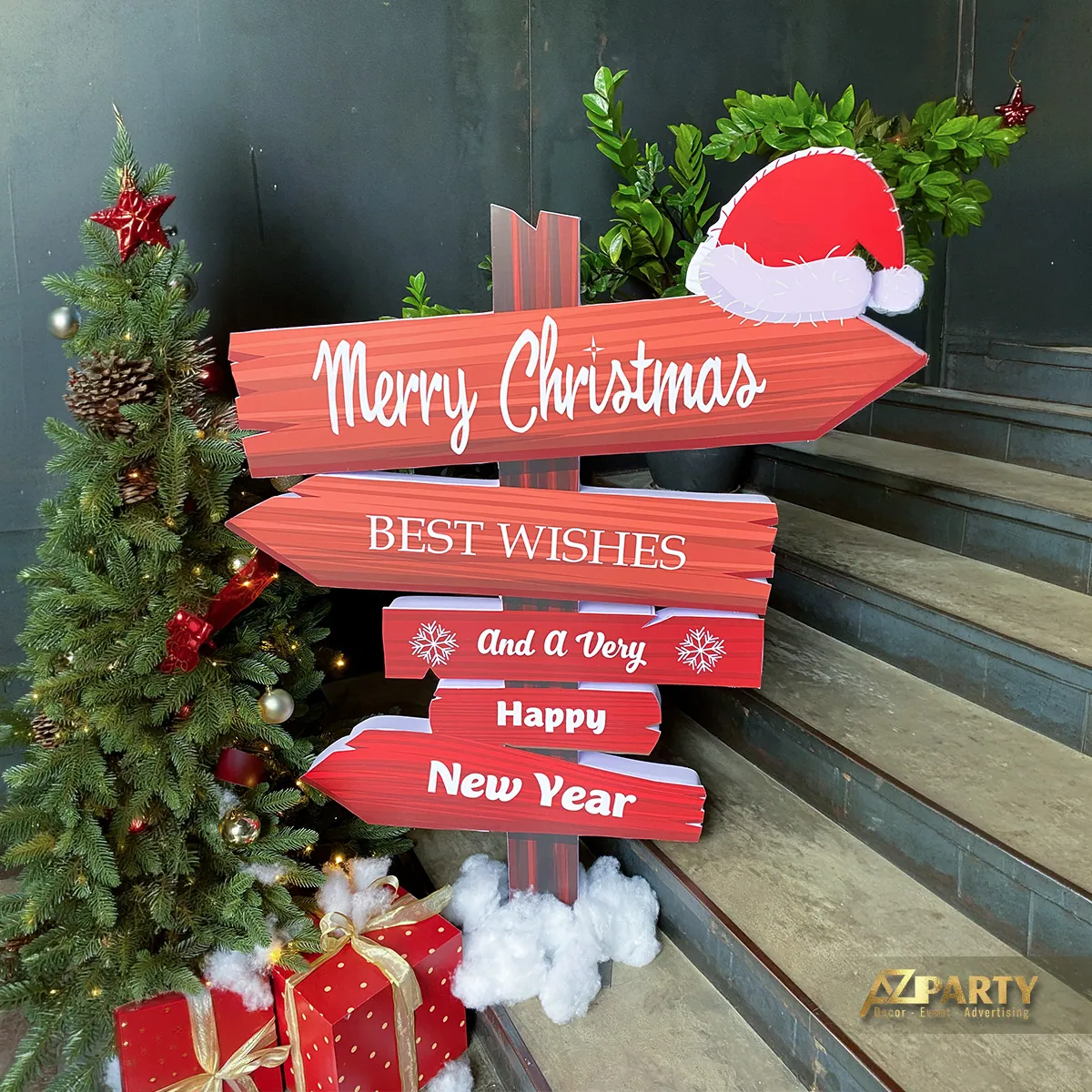 Cây thông Noel cạnh các bảng chỉ dẫn Merry Christmas và lời chúc năm mới