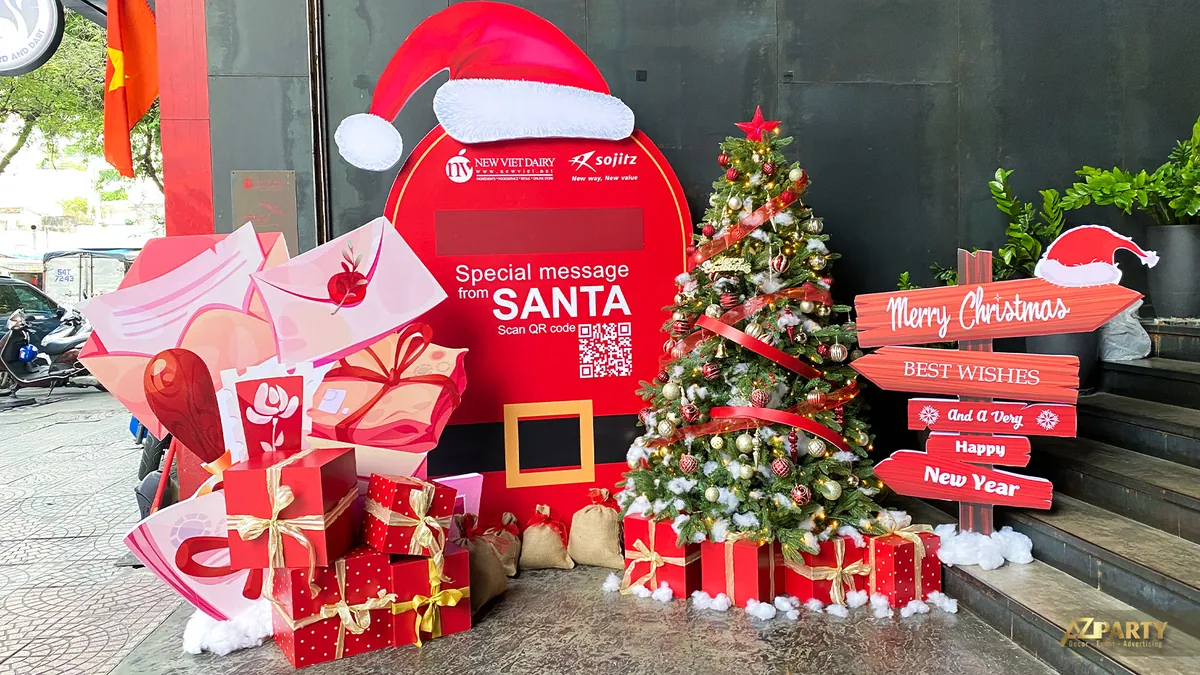 Cụm trang trí Noel New Viet Dairy gồm cây thông, bảng Santa và hộp quà
