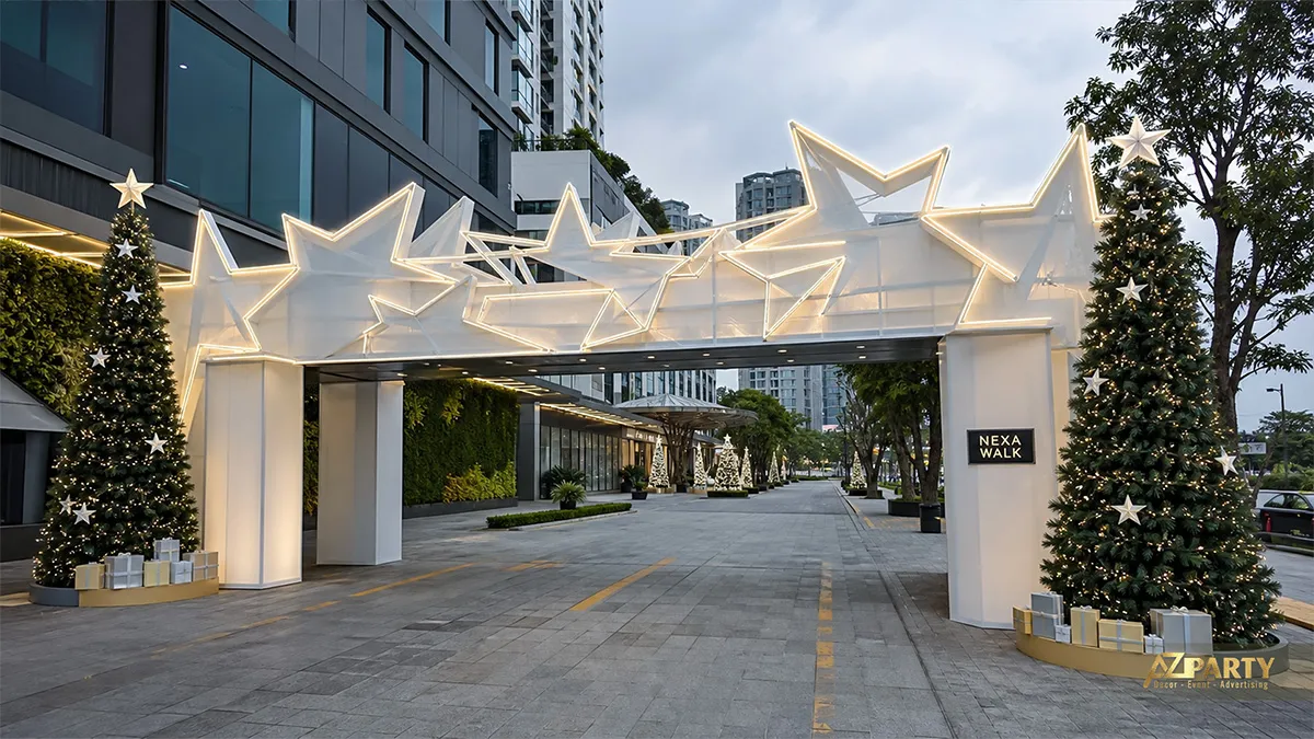 Cổng Noel ngoài trời khung trắng, sao phát sáng và hai cây thông trên lối xe
