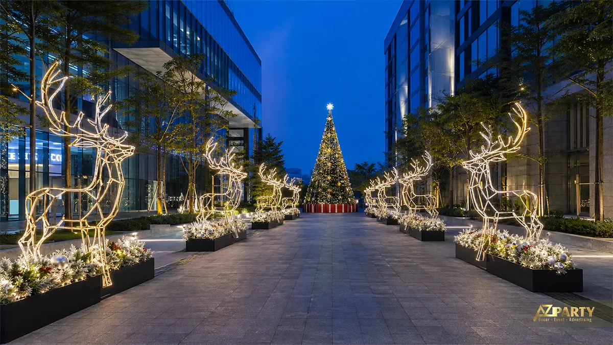 Lối đi ban đêm với tuần lộc đèn hai bên và cây thông Noel ở cuối trục