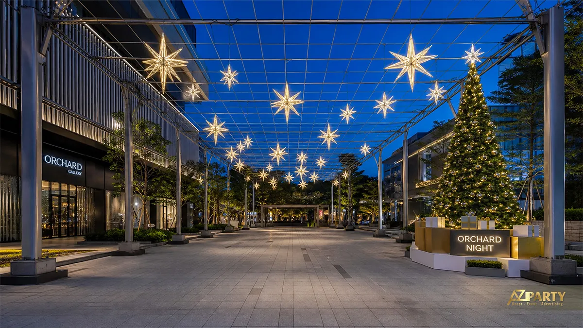 Phố đi bộ trang trí sao đèn vàng treo cao và cây thông Noel về đêm