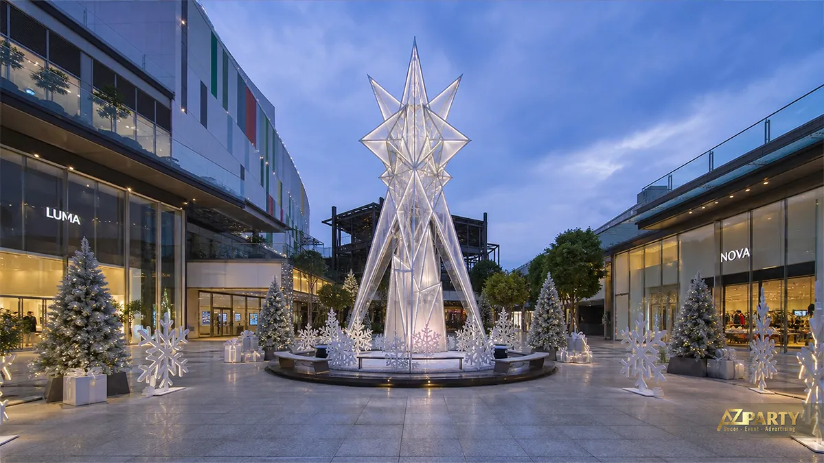 Quảng trường Noel tông trắng với ngôi sao pha lê cao, cây phủ tuyết và quà tặng