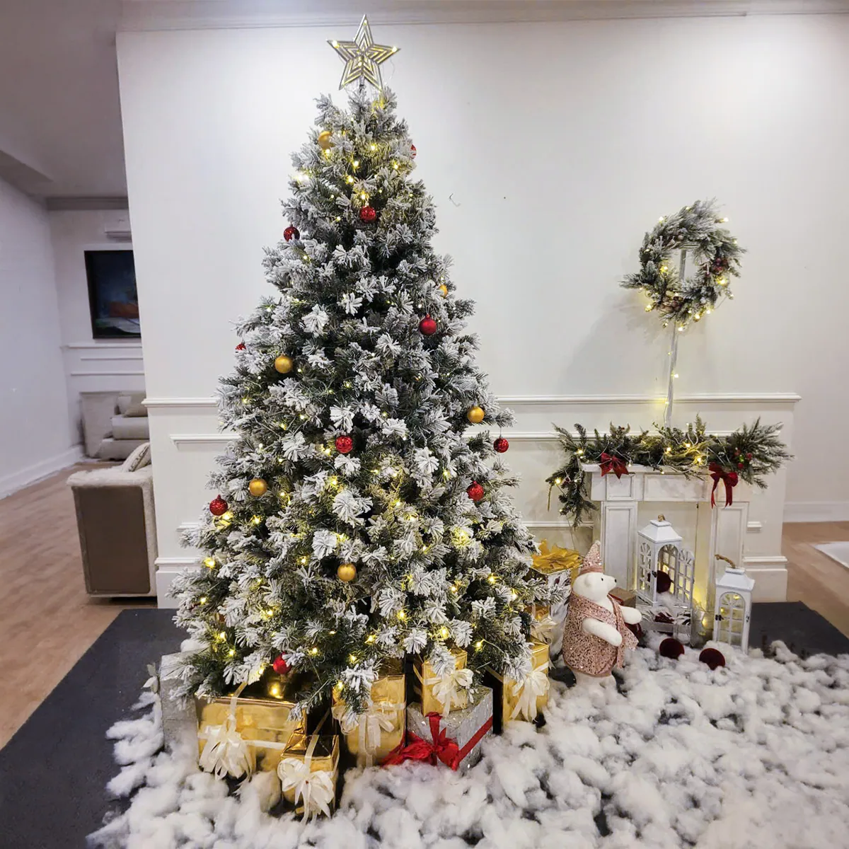 Cây thông Noel lớn phủ tuyết với hộp quà và đồ trang trí trong nhà