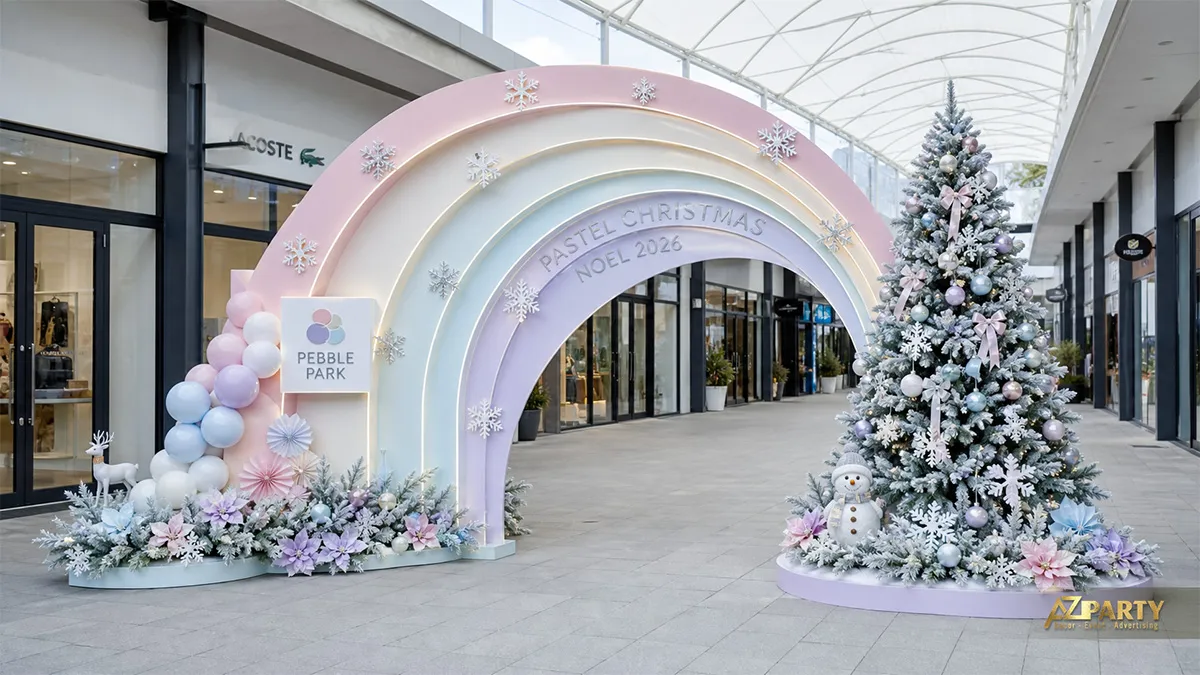 Mặt tiền Pebble Park với vòm cầu vồng pastel, cây thông, bóng bay và hoa