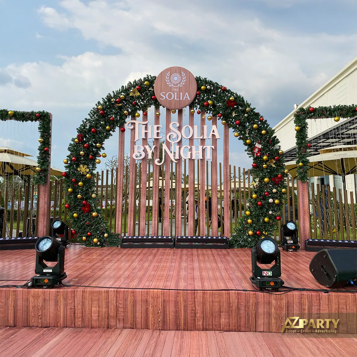 Sân khấu Noel The Solia với cổng vòm phủ hoa lá, đèn trang trí và sàn gỗ