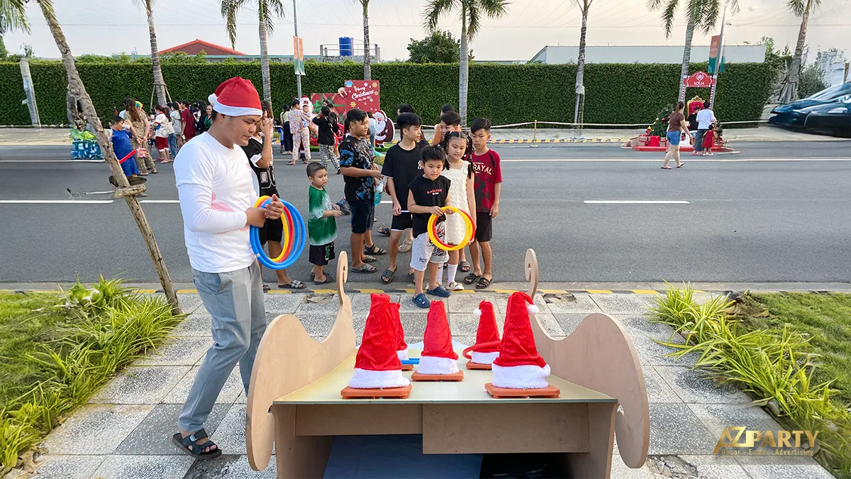 Trò chơi ném vòng với người tham gia đội mũ Noel bên cạnh đường nội khu