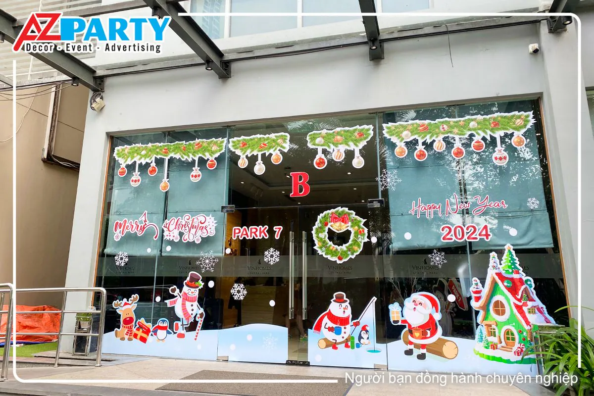 Cửa kính sảnh B tại Vinhomes được dán decal noel đầy màu sắc, có các họa tiết như ông già noel, người tuyết, con tuần lộc, ngôi nhà gỗ, và dòng chữ "Merry Christmas" nổi bật