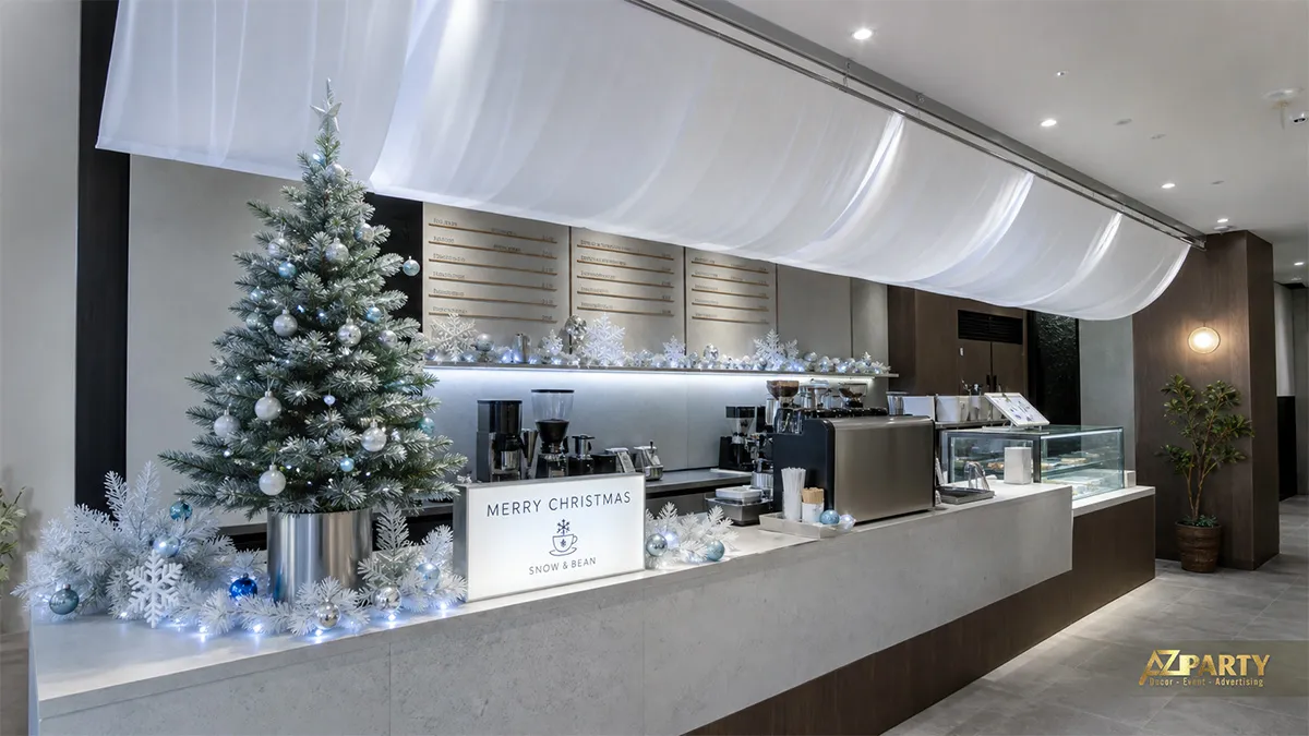 Quán Snow and Bean với cây thông bạc, rèm trắng trên trần và quả châu ánh kim