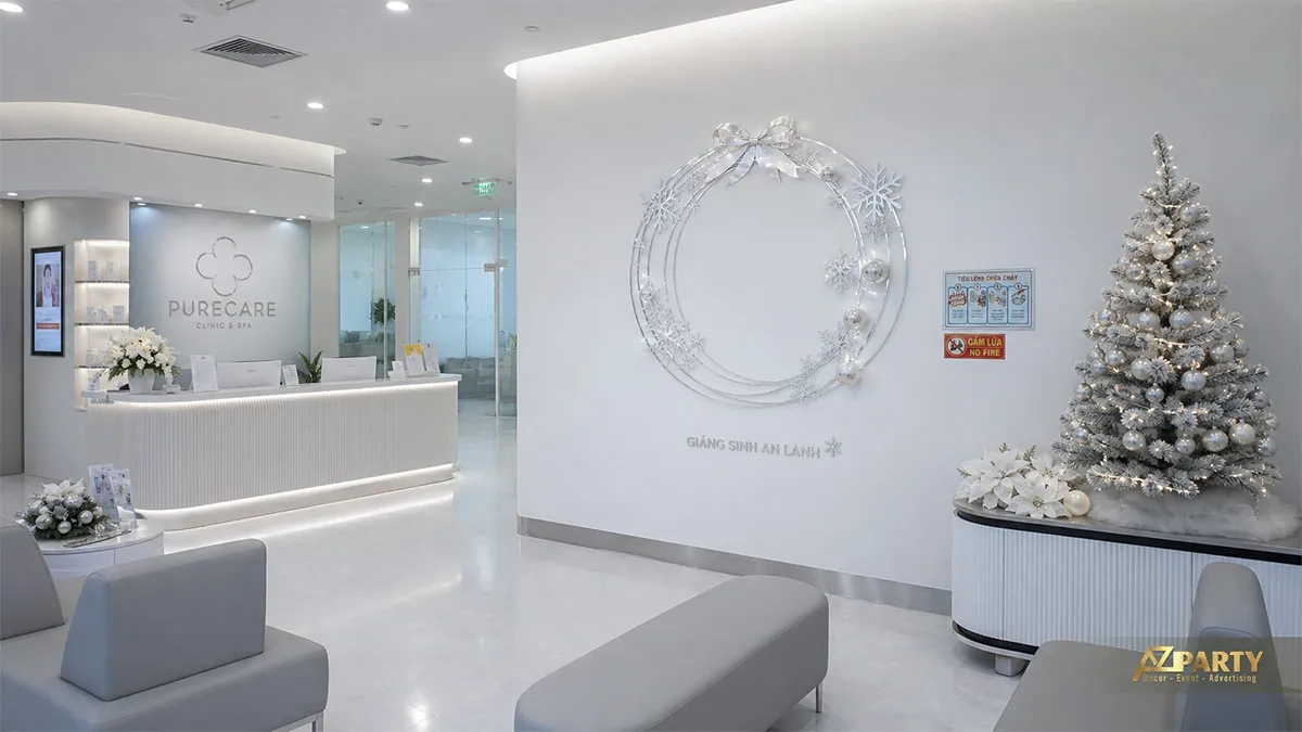 Quầy lễ tân Purecare Clinic với cây thông bạc, vòng tròn bạc và nền trắng tối giản