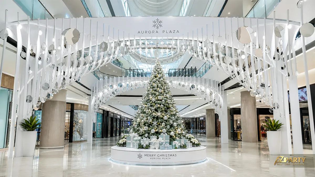 Đại sảnh Aurora Plaza với các dải trắng treo và cây thông ở trung tâm