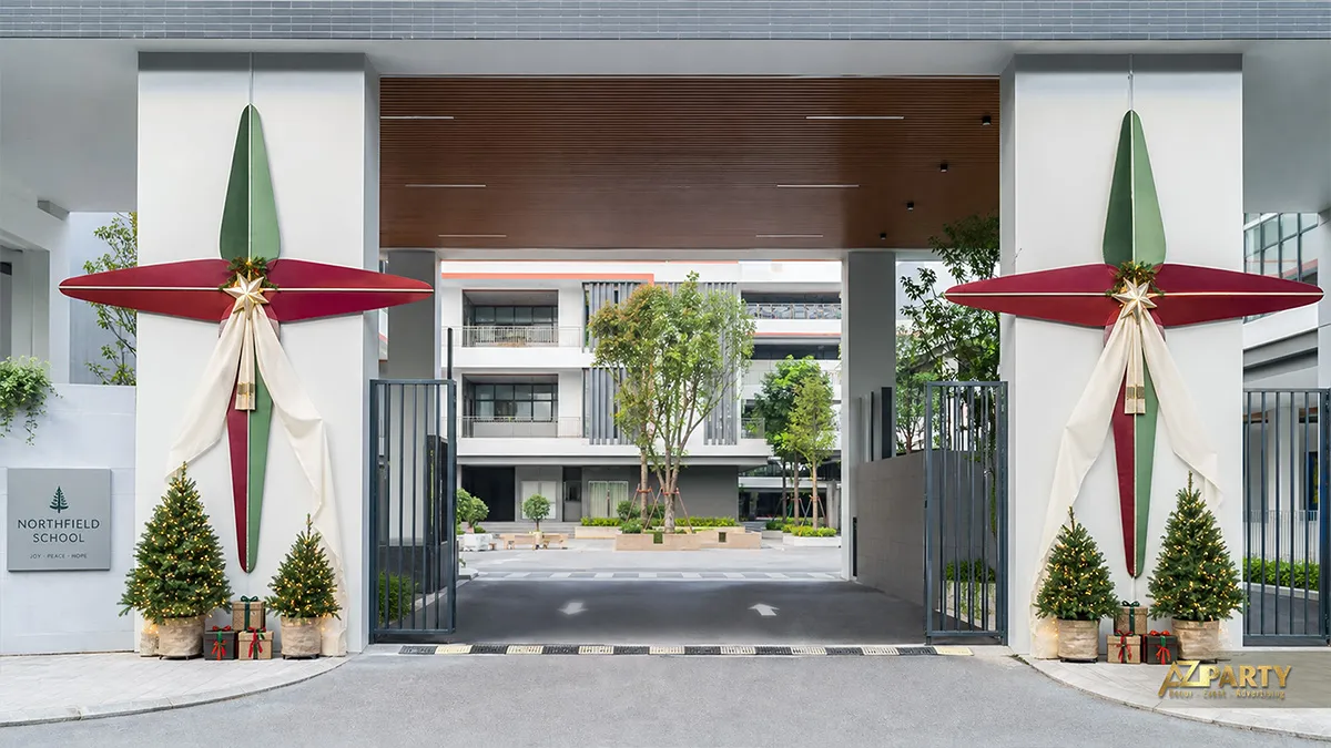 Cổng trường tạo hình ngôi sao đỏ xanh cùng các cây thông nhỏ