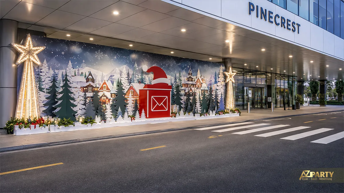 Mặt tiền trung tâm thương mại với backdrop làng tuyết, cây thông và hòm thư Noel màu đỏ