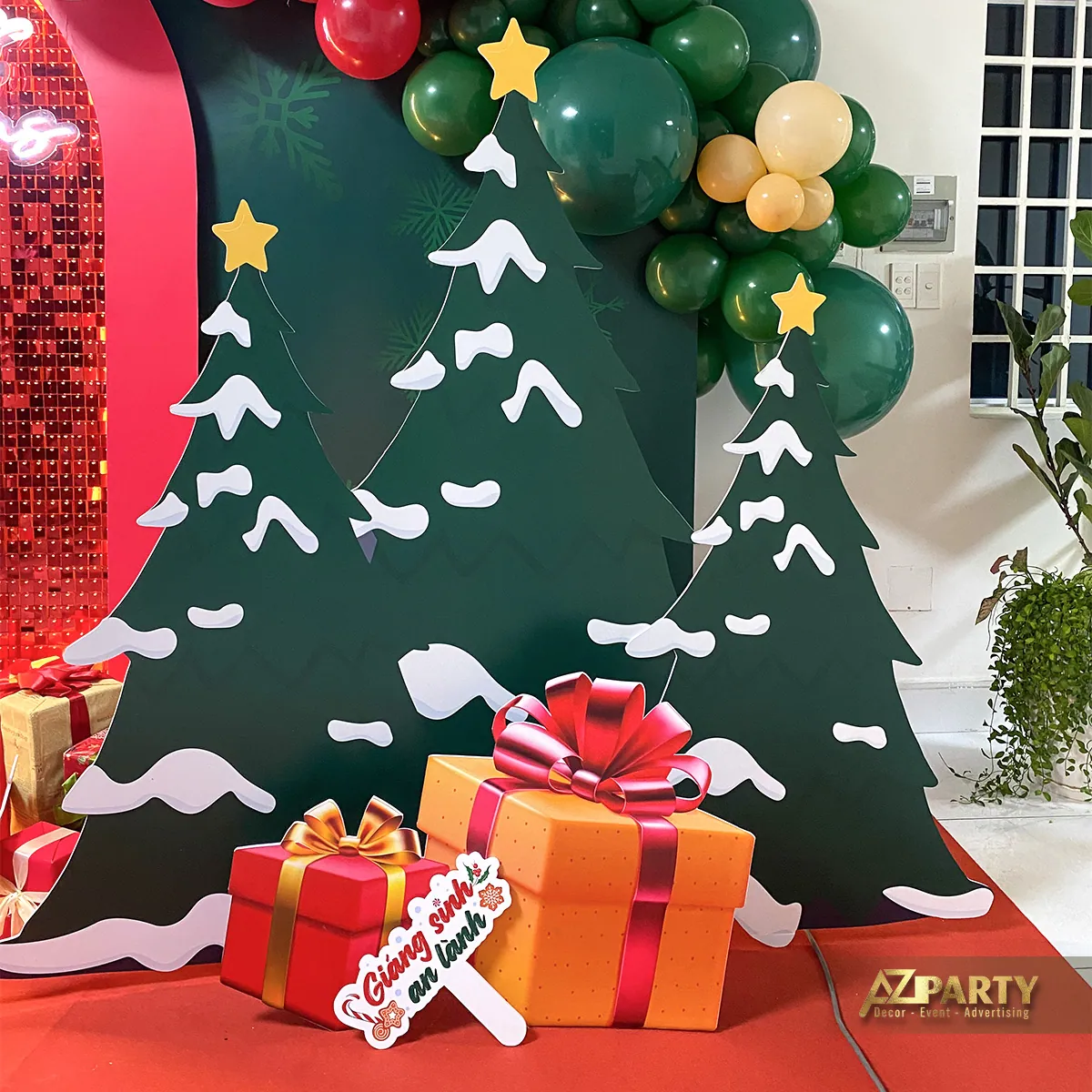 Tiểu cảnh Noel trong nhà với cây thông cách điệu, cây trắng và các hộp quà trên nền đỏ xanh