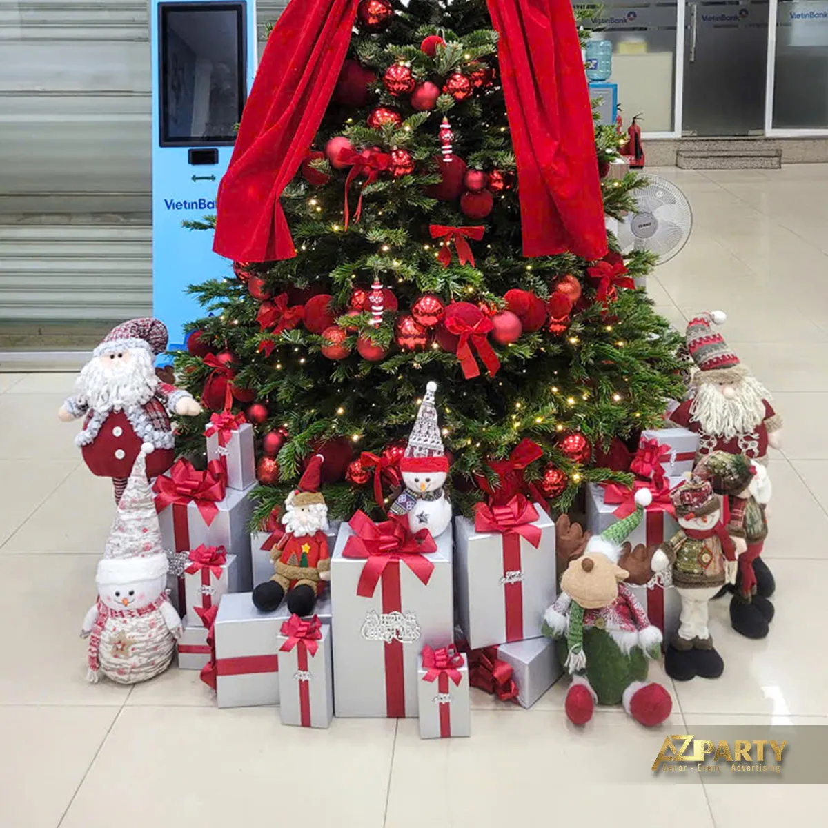 Cận cảnh cây thông Noel phủ đồ trang trí đỏ xanh cùng các hộp quà và thú Noel