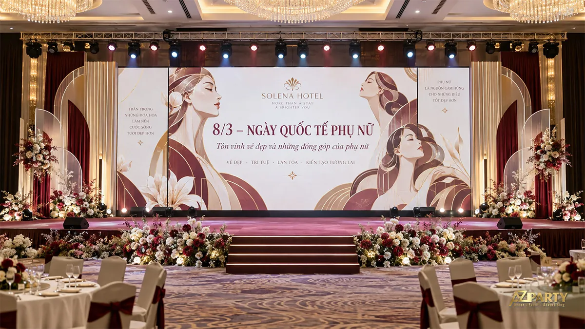 Sân khấu phòng tiệc có màn hình chân dung phụ nữ nét vẽ, vòm vàng và rèm đỏ rượu vang hai bên