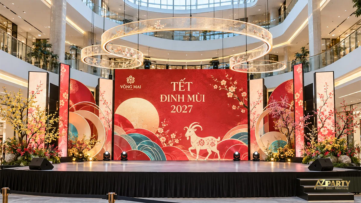 Sân khấu tại sảnh trung tâm thương mại với vòng đèn treo và hoa mai đào