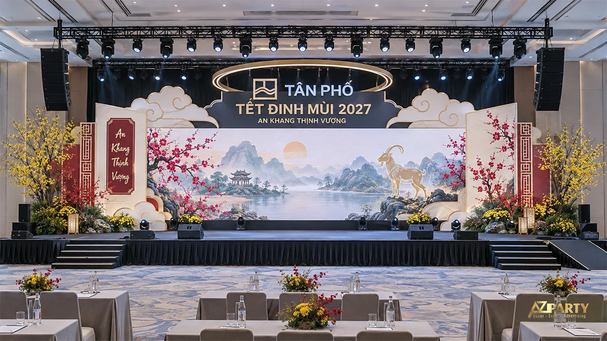 Sân khấu tông xanh đậm kem với đèn vòng treo và tranh núi sông