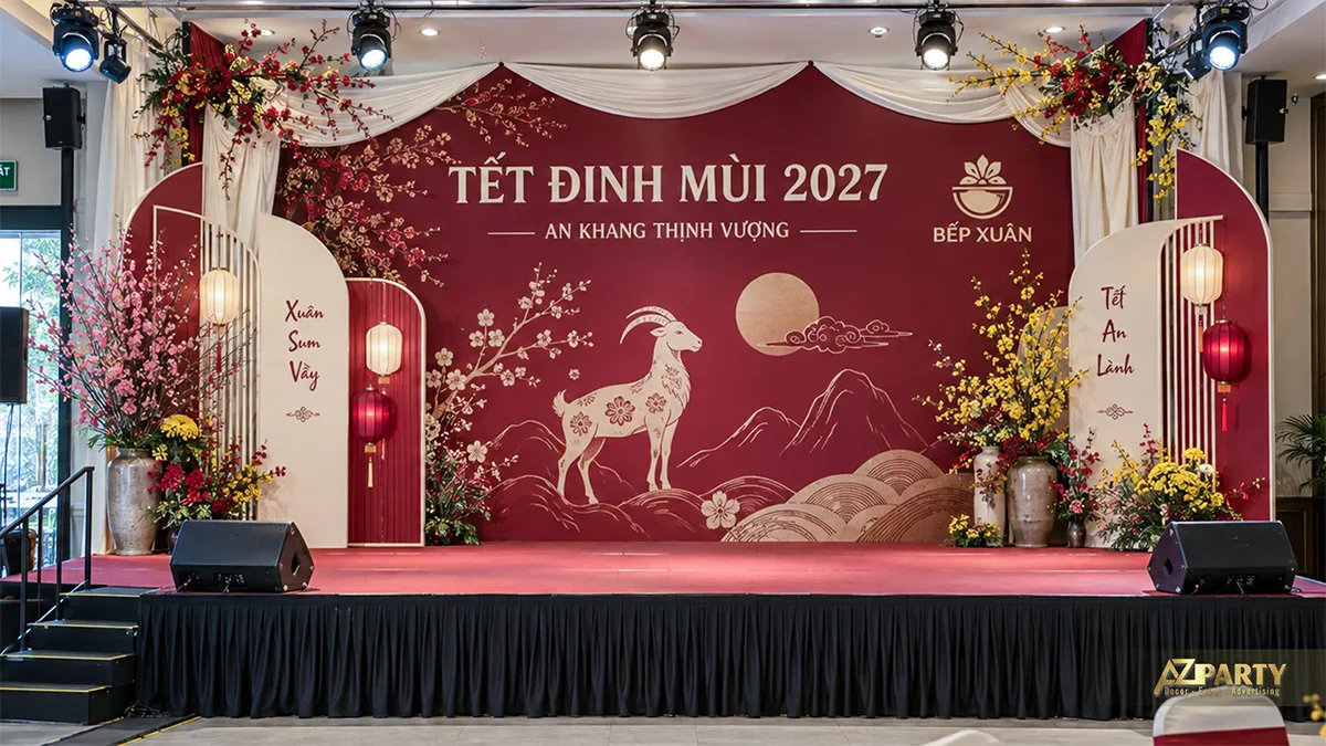 Sân khấu đỏ mận với màn vải buông, đèn lồng và hình dê trên nền núi