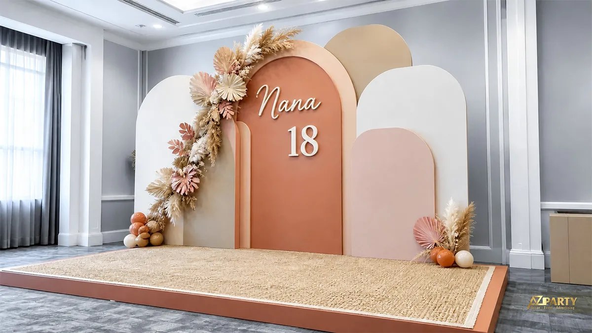 Backdrop sinh nhật 18 tuổi cho Nana tông cam đào kem, phối hoa khô và sân khấu tối giản.
