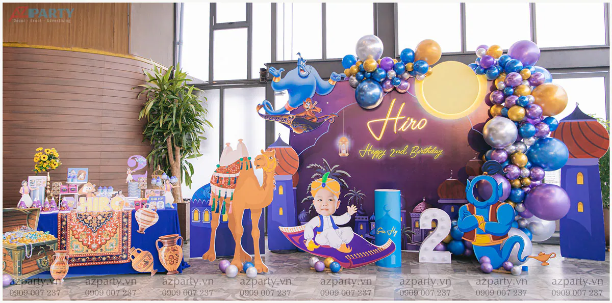 Sân khấu tiệc sinh nhật bé Hiro 2 tuổi chủ đề Aladdin và cây đèn thần độc đáo với các mô hình nhân vật hoạt hình Genie, lạc đà và bé cưỡi thảm bay sinh động.