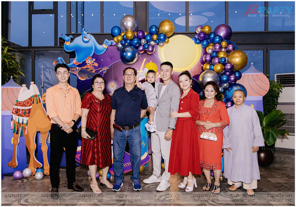 Đại gia đình chụp hình lưu niệm ấm cúng trước sân khấu sinh nhật trang trí lộng lẫy của bé Hiro.