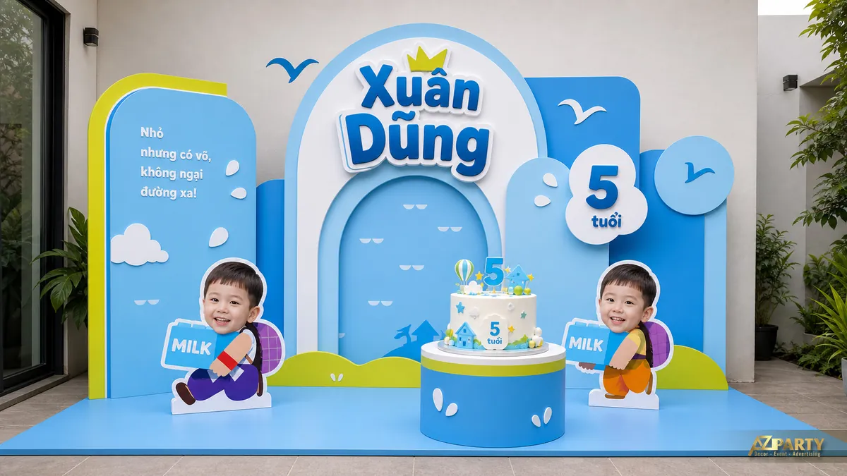 Backdrop xanh dương vàng cho bé Xuân Dũng 5 tuổi với hộp sữa, mây và mô hình nhỏ