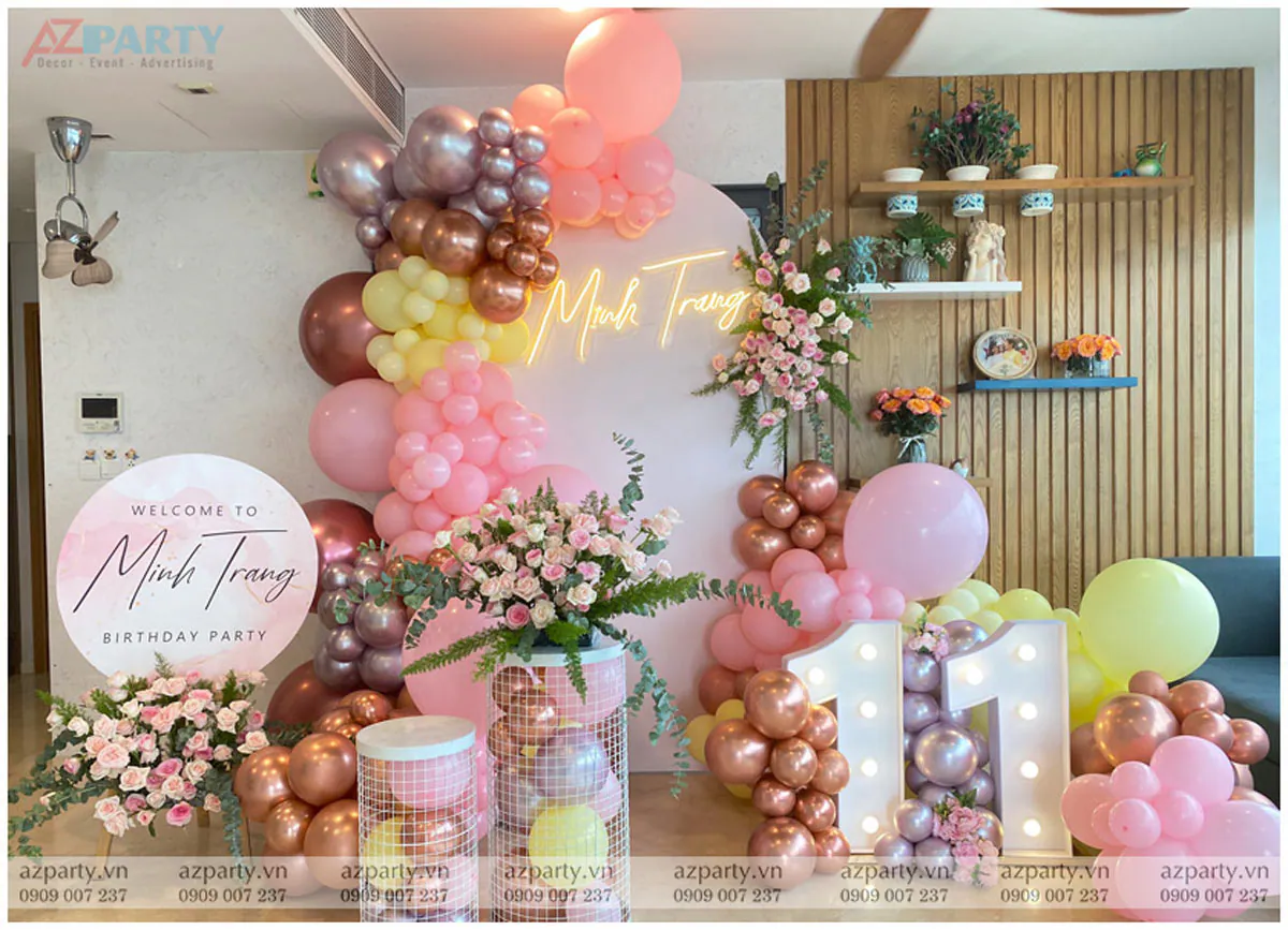 Trang trí tiệc sinh nhật bé Minh Trang tròn 11 tuổi với tone màu hồng pastel ngọt ngào, chữ số 11 phát sáng rực rỡ bên cạnh các cụm bong bóng nghệ thuật phối màu hồng, vàng, rose gold sang trọng và các lẵng hoa hồng tươi tắn.