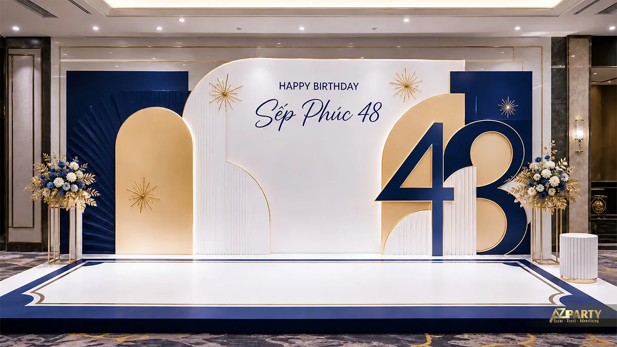 Backdrop sinh nhật sếp Phúc 48 tuổi tông navy gold, phối số 48, hoa trắng và họa tiết hình học.