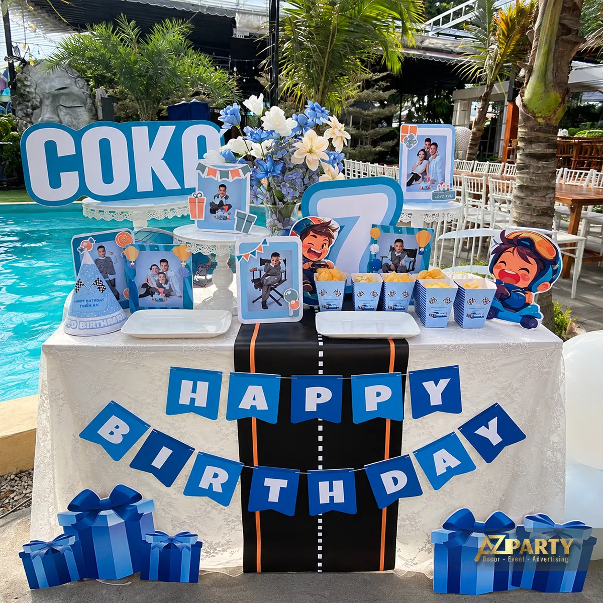 Bàn gallery phủ khăn trắng với dải đường đua đen và dây chữ Happy Birthday