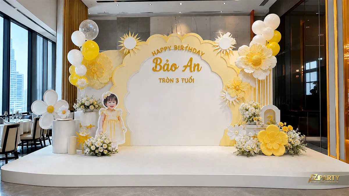Backdrop sinh nhật vàng trắng với hoa và cụm bóng nhẹ