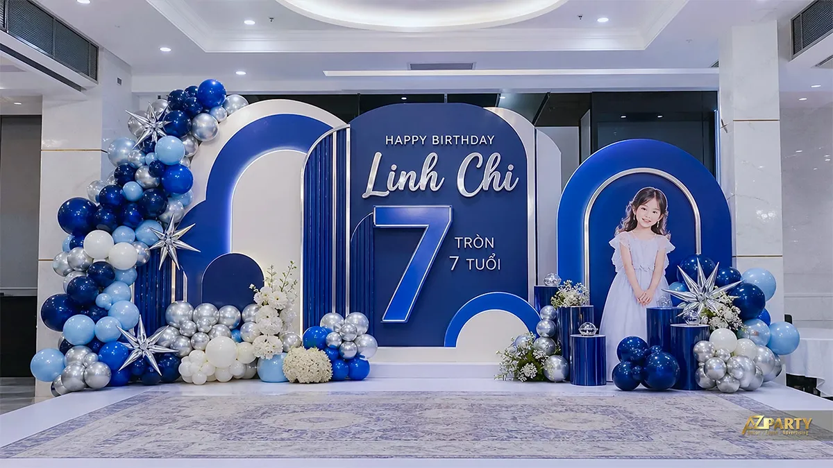 Backdrop xanh navy mừng sinh nhật Linh Chi tròn 7 tuổi, có số 7, sao và bóng bạc.