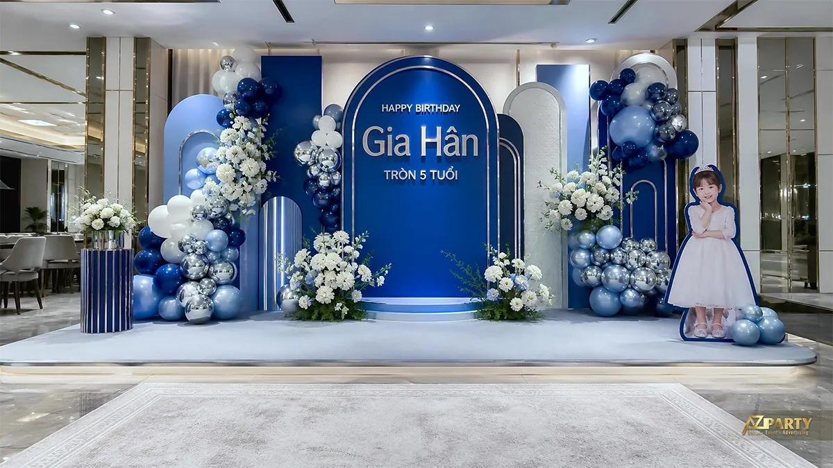 Backdrop xanh navy mừng sinh nhật Gia Hân tròn 5 tuổi, phối hoa trắng và bóng bạc.