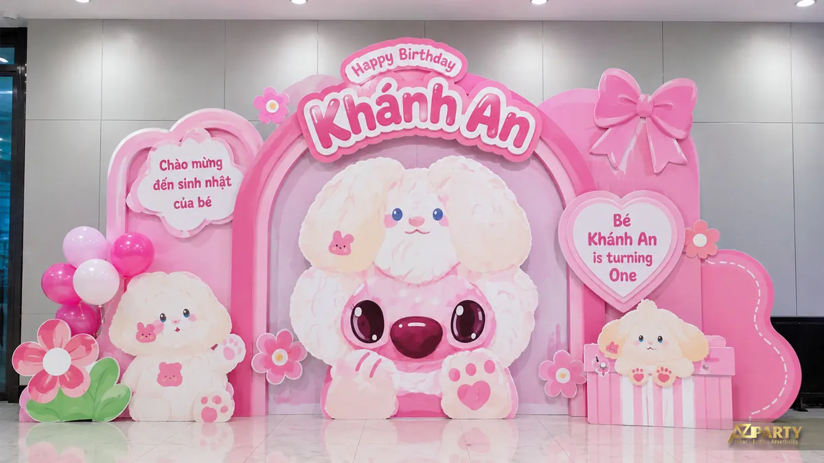 Backdrop sinh nhật màu hồng với nhân vật tai dài lông trắng, nơ lớn, hoa và cụm bóng nhỏ