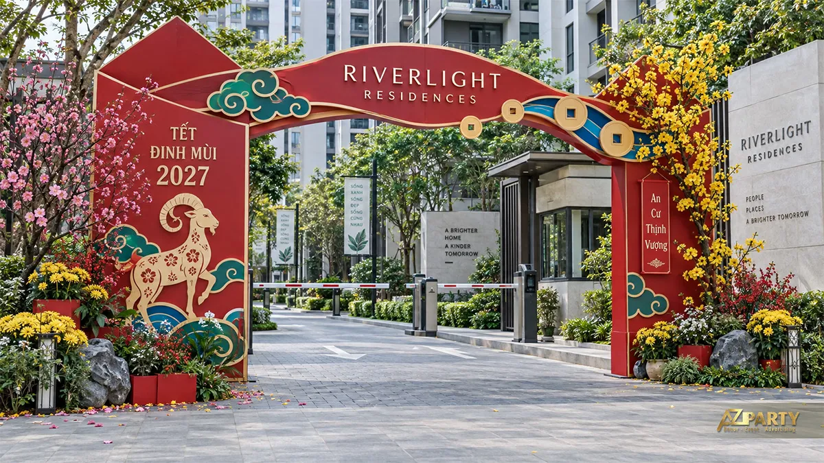 Cổng chào Tết đỏ xanh ở lối vào khu căn hộ với dê, hoa mai đào và đồng tiền cổ
