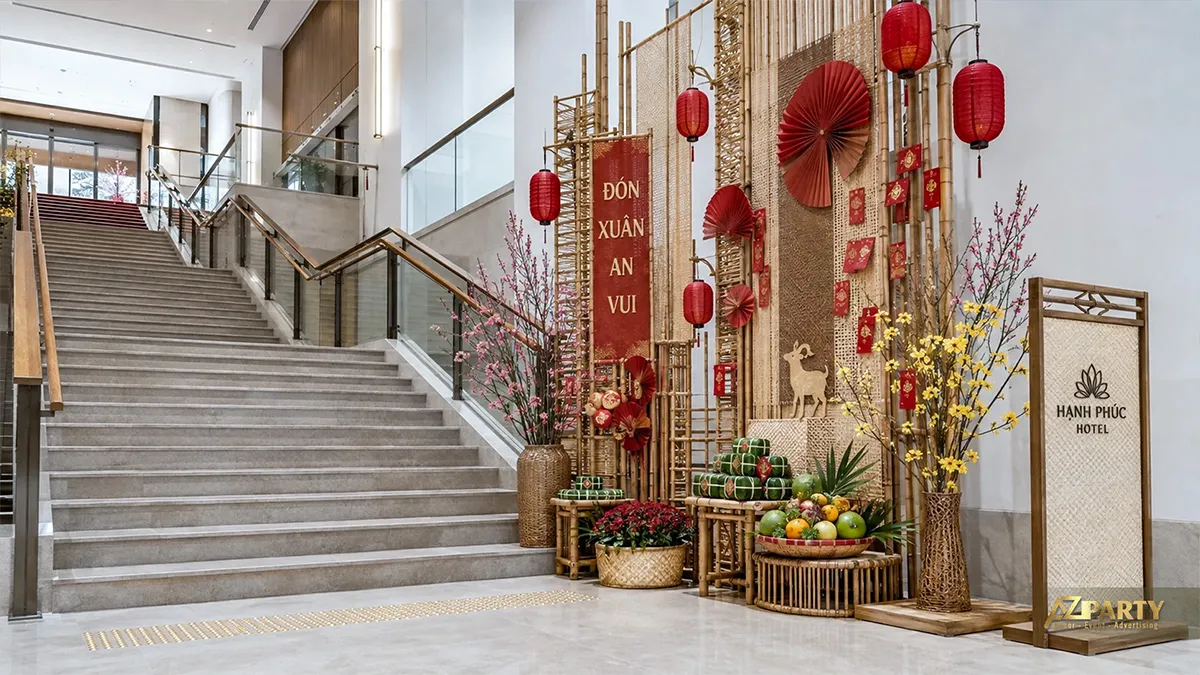 Góc trang trí Tết cạnh cầu thang Hạnh Phúc Hotel với tre đan, đèn lồng, bánh chưng và mâm quả