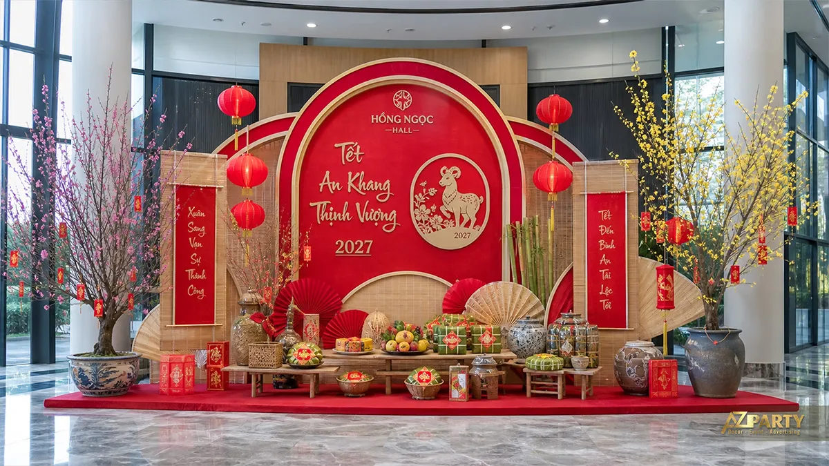 Tiểu cảnh Tết An Khang Thịnh Vượng tại Hồng Ngọc Hall với phông đỏ, tre đan, mai đào và mâm lễ