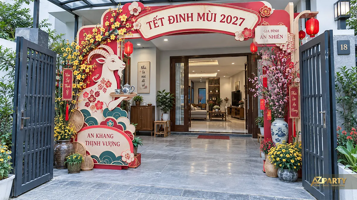 Cổng Tết trước sân với linh vật dê lớn và hai cụm hoa xuân