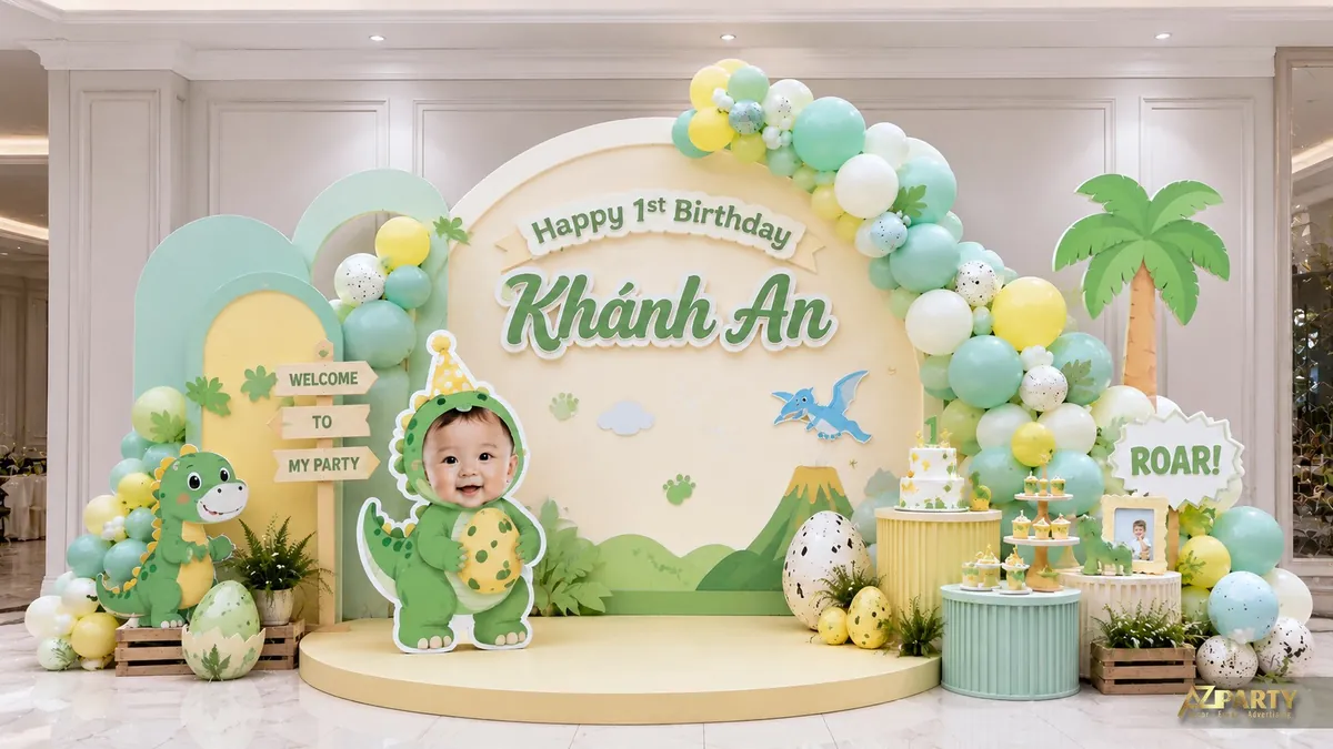 Sân khấu thôi nôi Khánh An chủ đề khủng long xanh vàng với trứng và núi lửa