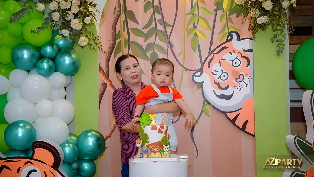 Mẹ bế bé Đức Khang (Bào Ngư) chụp ảnh cùng chiếc bánh kem trang trí hình muông thú