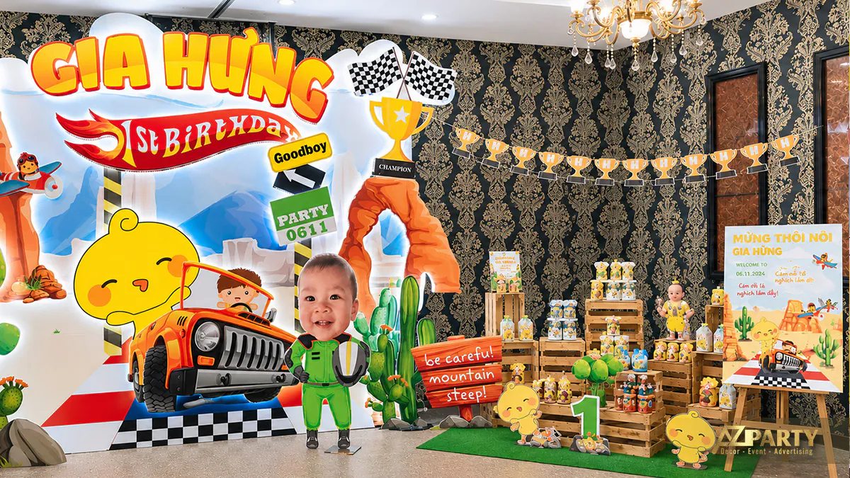 Mô hình chibi bé Gia Hưng mặc đồ tay đua chuyên nghiệp đứng cạnh chiếc xe jeep màu cam năng động trên sân khấu