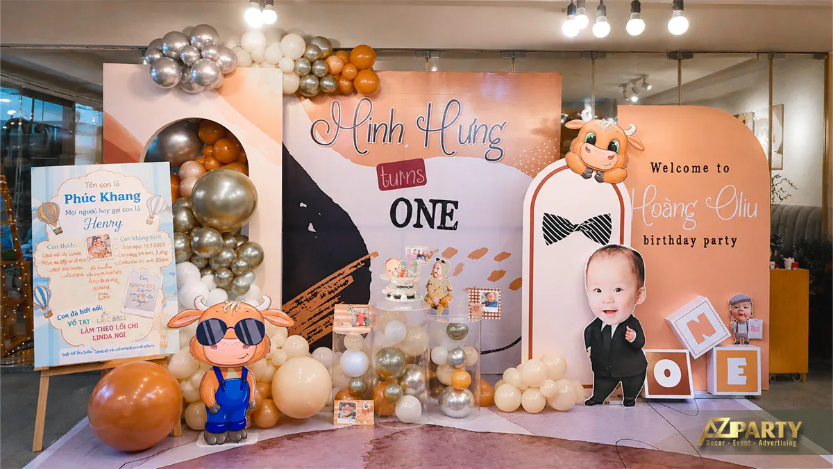 Bảng thông tin thôi nôi đặt bên cạnh sân khấu photobooth rực rỡ của bé Minh Hưng trong nhà hàng