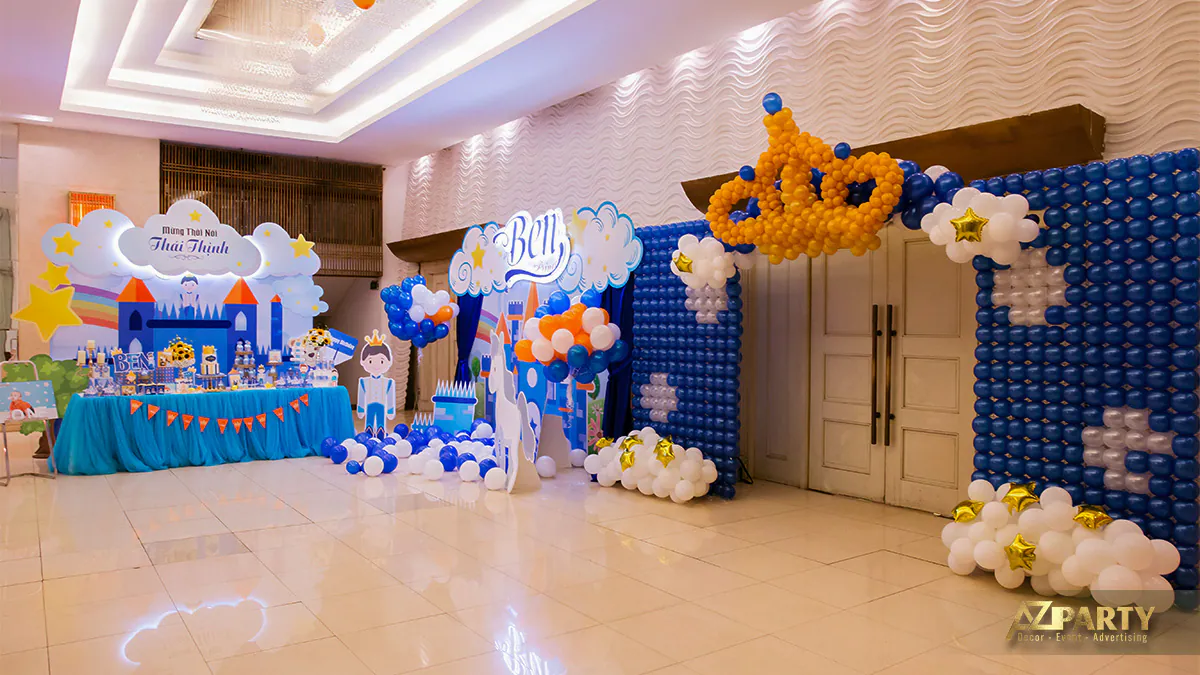 Cổng chào bong bóng nghệ thuật hình vương miện khổng lồ tông màu xanh vàng dẫn vào phòng tiệc thôi nôi của bé Thái Thịnh