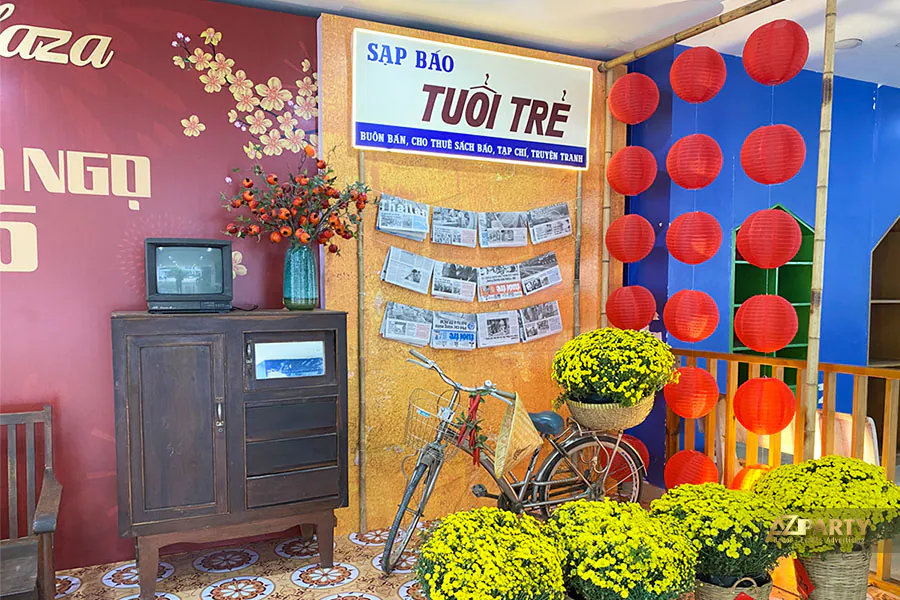 Góc tiểu cảnh Tết xưa với sạp báo Tuổi Trẻ, xe đạp cổ, đèn lồng đỏ và hoa cúc vàng