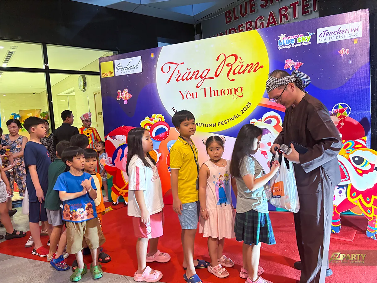 Nghệ sĩ hoạt náo giao lưu cùng cư dân nhí trước backdrop Trung thu