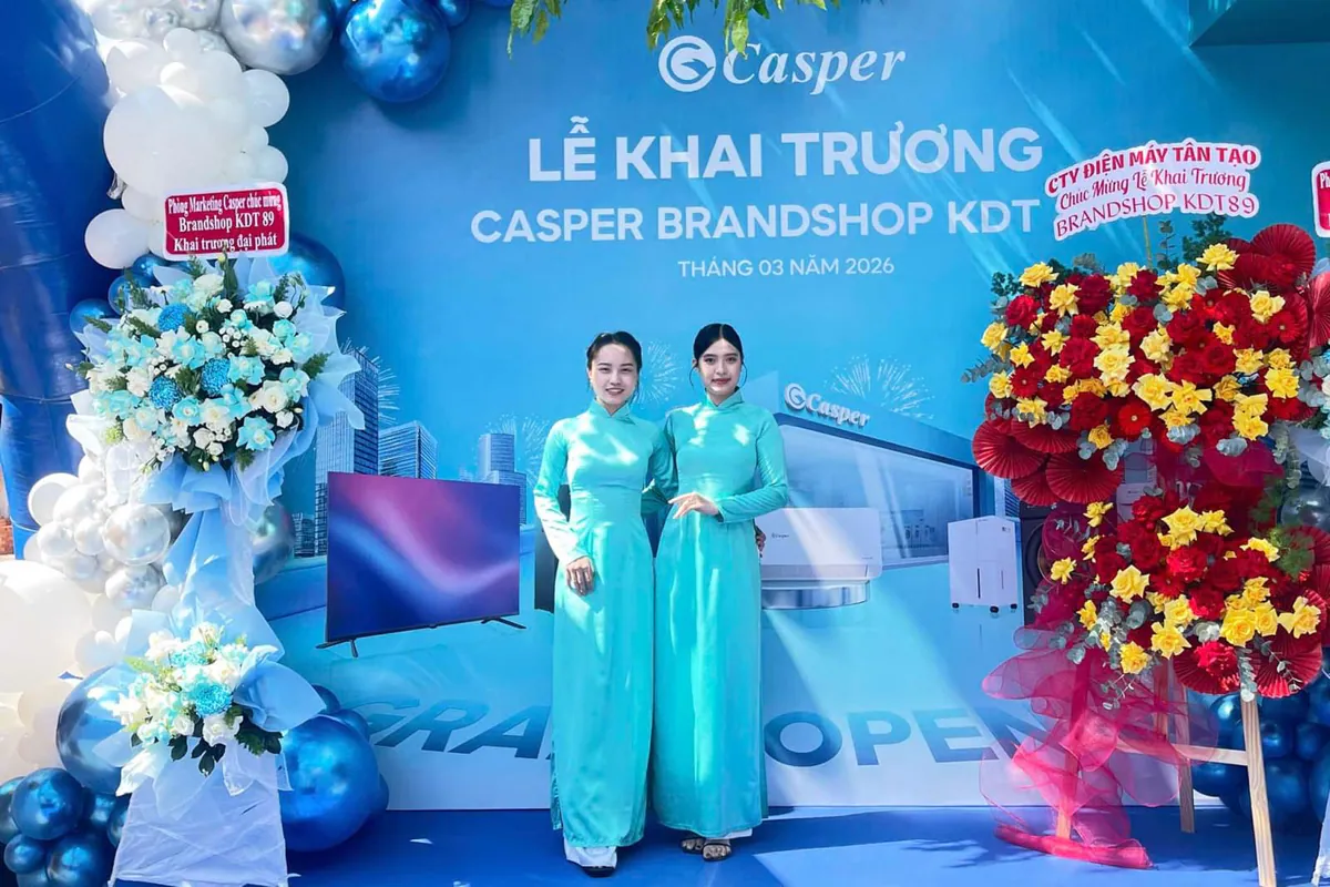 2 nhân sự PG mặc áo dài xanh ngọc (theme của buổi lễ) đứng tạo tạo dáng chụp hình trên sân khấu